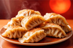 Close-up of a plate with several fried Nepalese momo dumplings and two sauces.